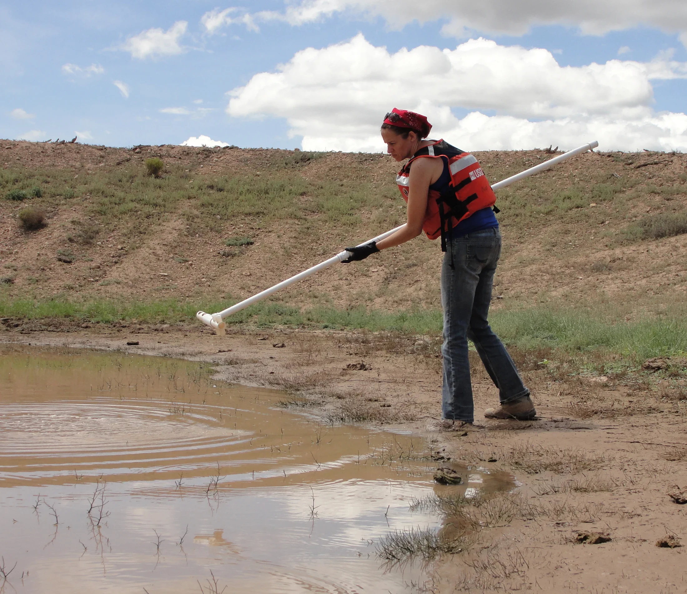 Scientist collecting pond-water samples near breccia-pipe uranium mines for environmental DNA analysis to evaluate the presence of species, approximately 2015.